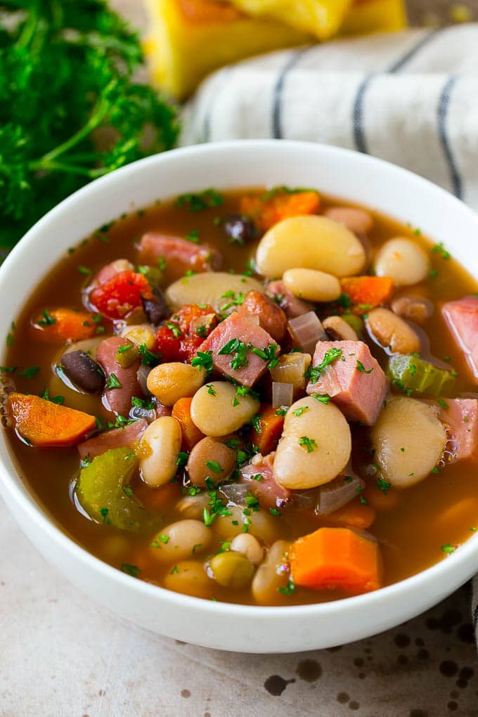 A bowl of ham and bean soup made with dried beans, ham and vegetables, then topped with fresh parsley.