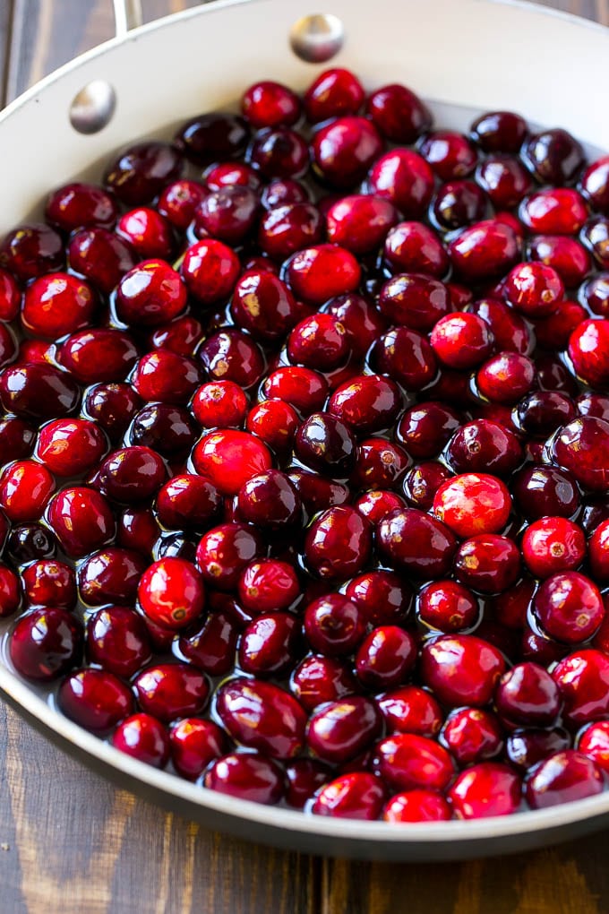 Cranberries with sugar and water in a skillet.