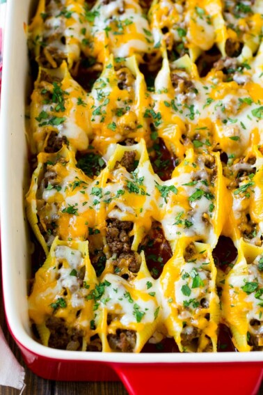 A baking dish of Mexican stuffed shells filled with ground beef and cheese.