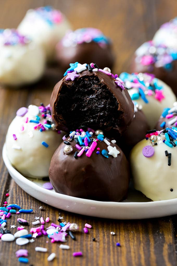 A plate of dark and white chocolate Oreo balls topped with colorful sprinkles.