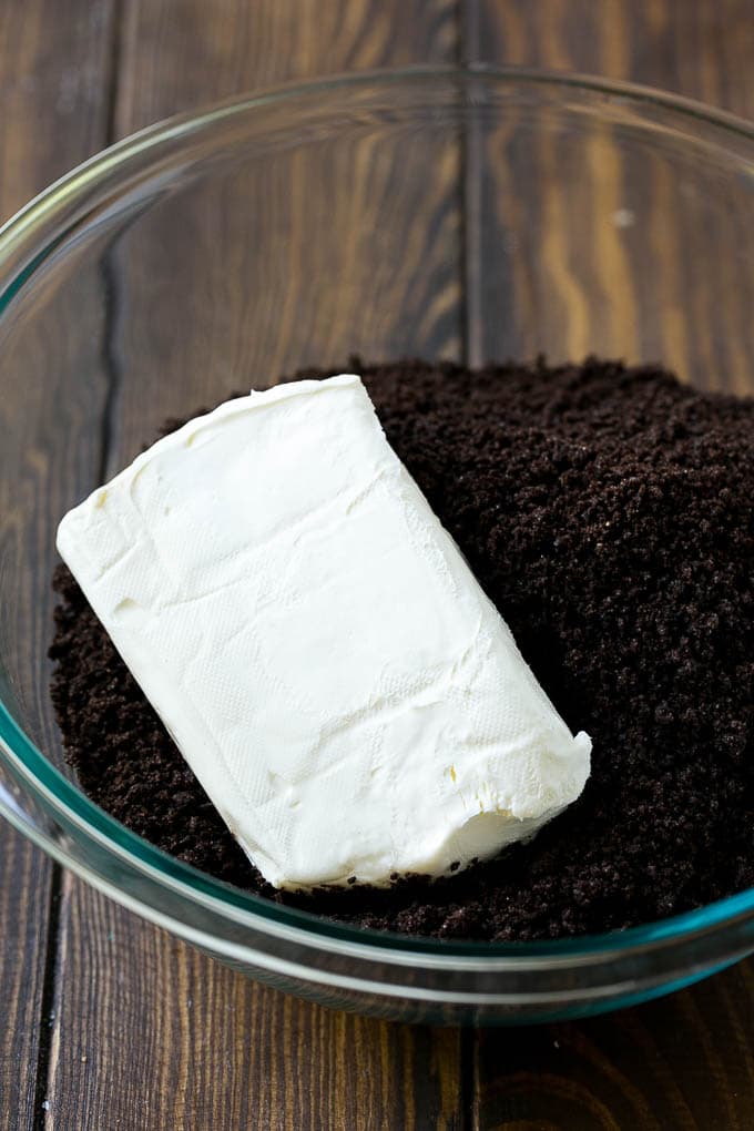 Cookie crumbs and cream cheese in a bowl.