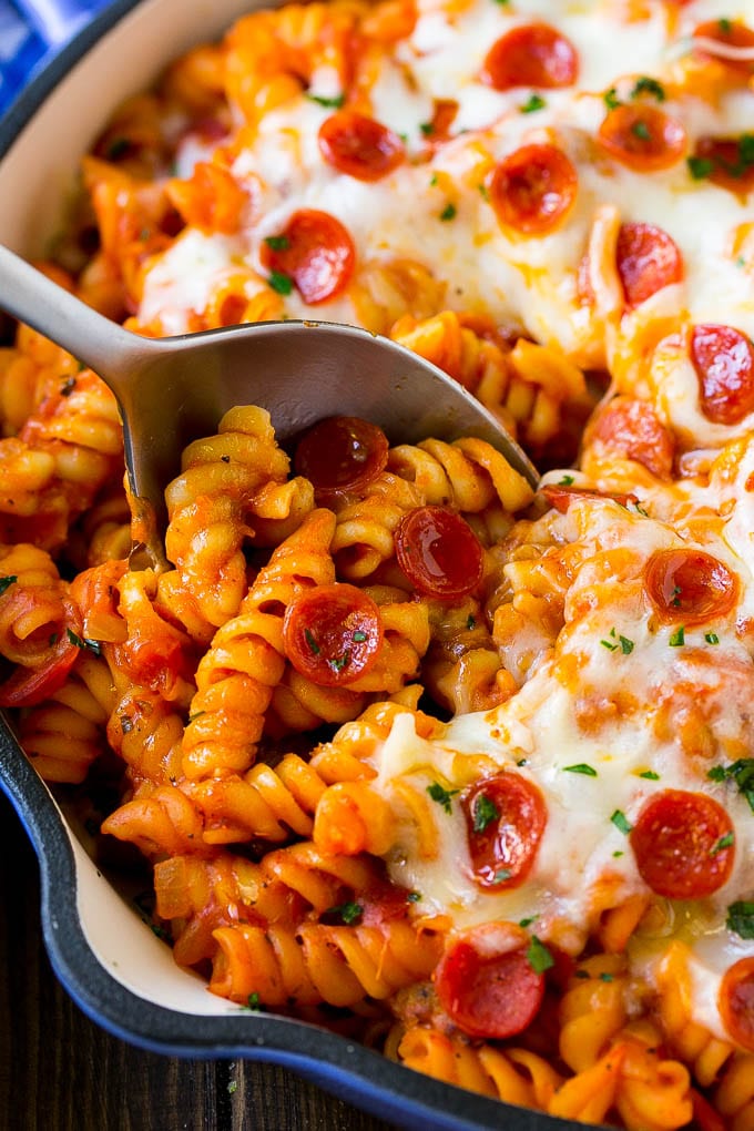 A pan of pizza pasta with a serving spoon in it.