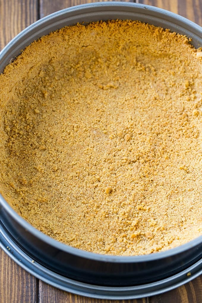 A graham cracker crust pressed inside a springform pan.