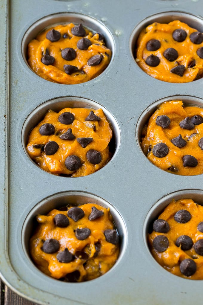 Pumpkin muffin batter in muffin tins.