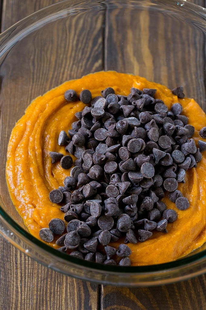 Pumpkin muffin batter with chocolate chips in a mixing bowl.