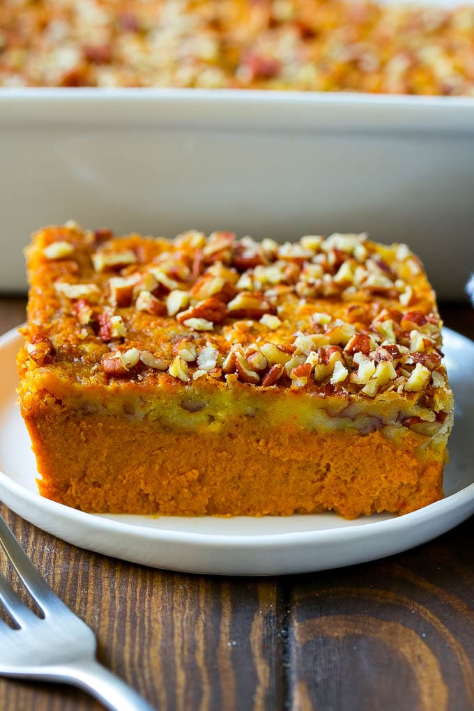 Una fetta di dump cake alla zucca condita con noci pecan.