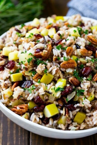 A serving bowl of rice pilaf made with wild rice, apples, cranberries and pecans.