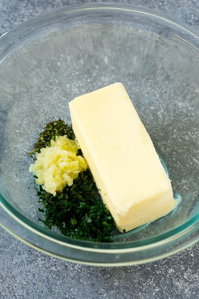 Butter, garlic, fresh minced herbs and salt and pepper in a mixing bowl.