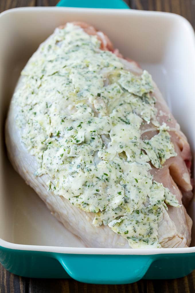 A turkey breast coated with garlic and herb butter.