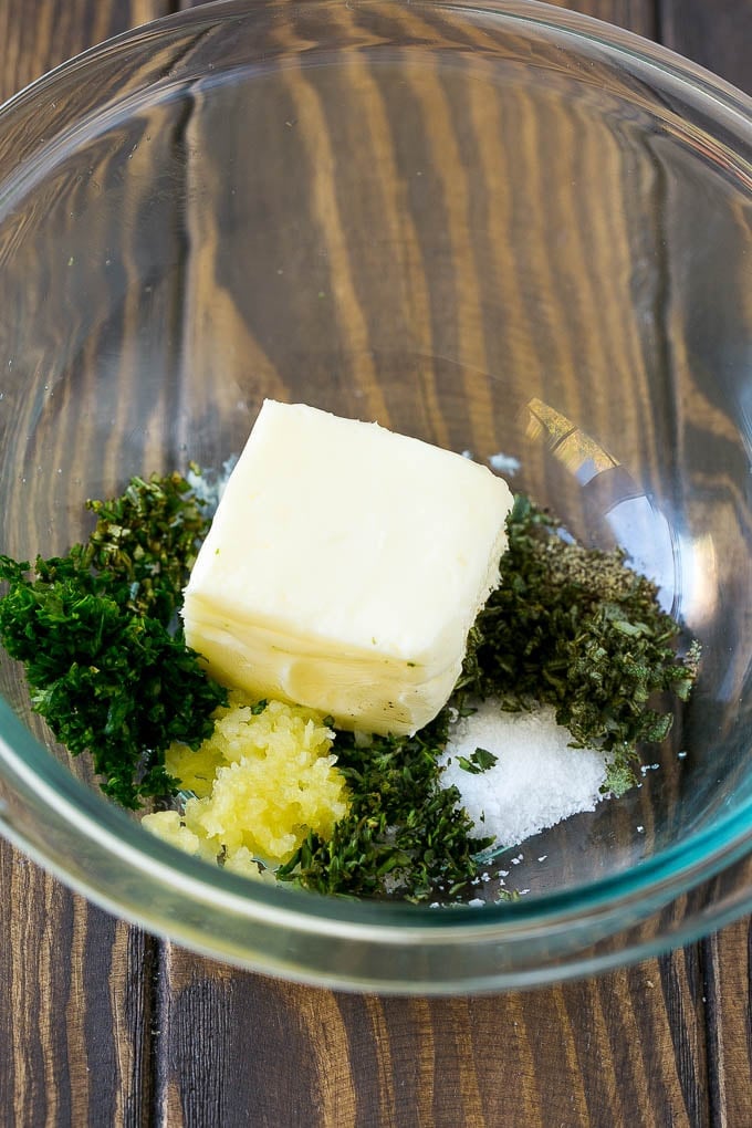 Butter, garlic, herbs and seasonings in a mixing bowl.