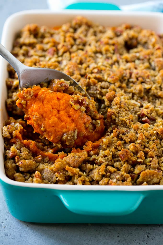 Ruth's Chris sweet potato casserole with a serving spoon in it.