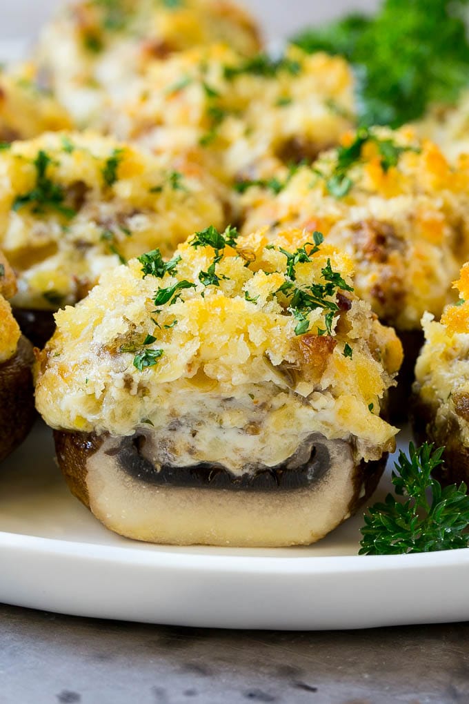 A cross section of a sausage stuffed mushroom on a serving platter.