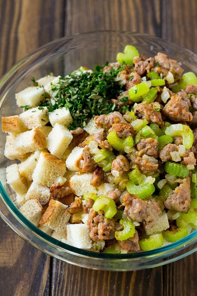 Sausage, sauteed vegetables and bread cubes in a mixing bowl.
