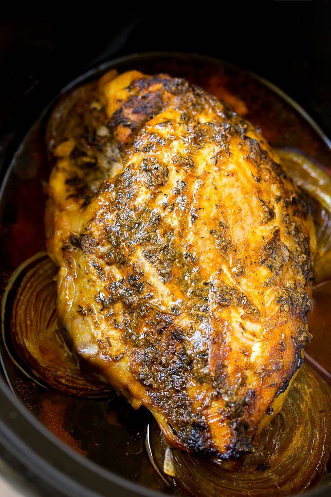 A cooked turkey breast inside a crock pot.