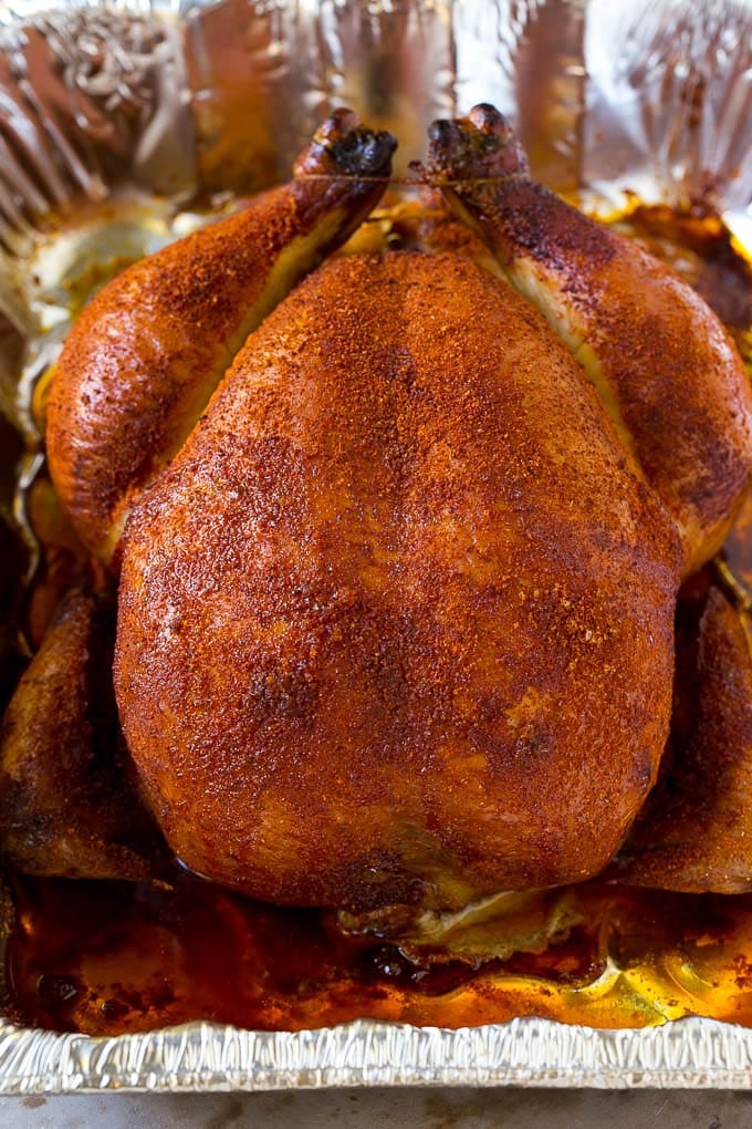 A whole smoked chicken in a roasting pan.