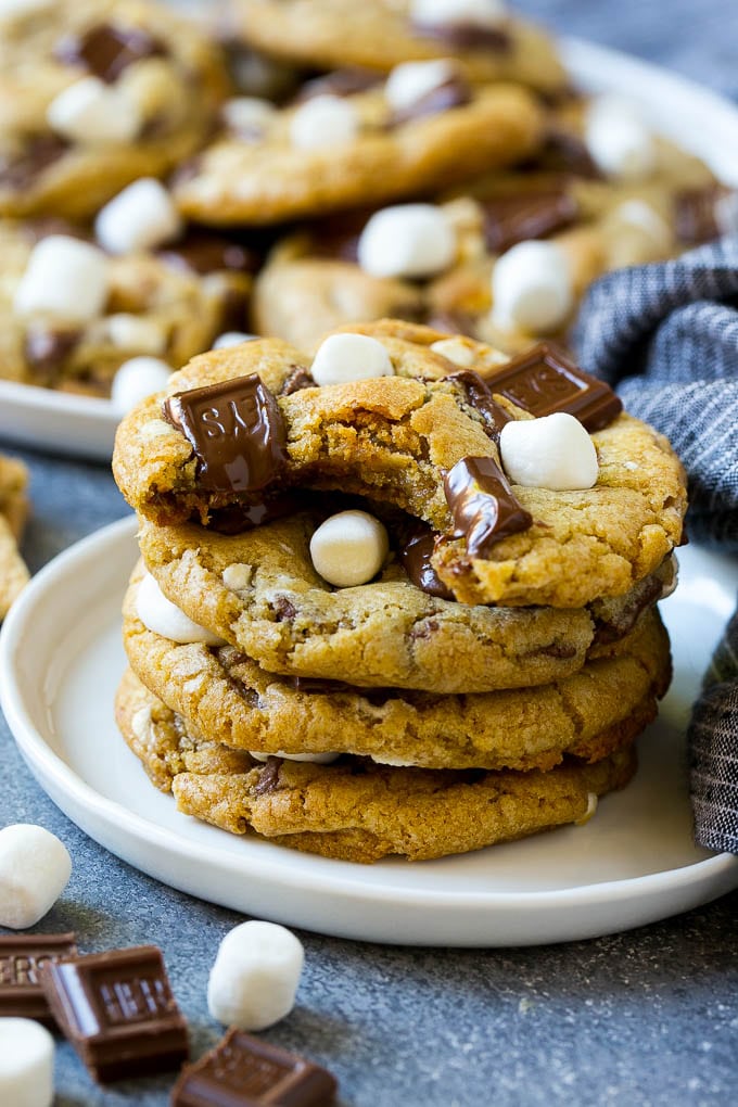 S'mores Cookies Recipe | Marshmallow Cookies #smores #marshmallow #chocolate #cookies #dessert #dinneratthezoo A stack of S'mores cookies with a bite taken out of one.