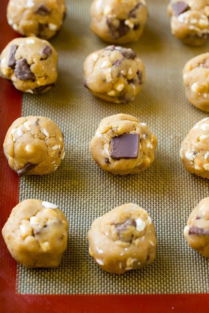 S'mores Cookies Recipe | Marshmallow Cookies #smores #marshmallow #chocolate #cookies #dessert #dinneratthezoo Balls of cookie dough on a baking sheet.