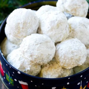 Snowball cookies coated in powdered sugar and served in a holiday tin,