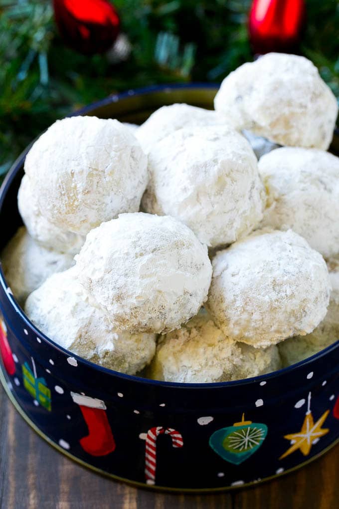 Snowball cookies coated in powdered sugar and served in a holiday tin,