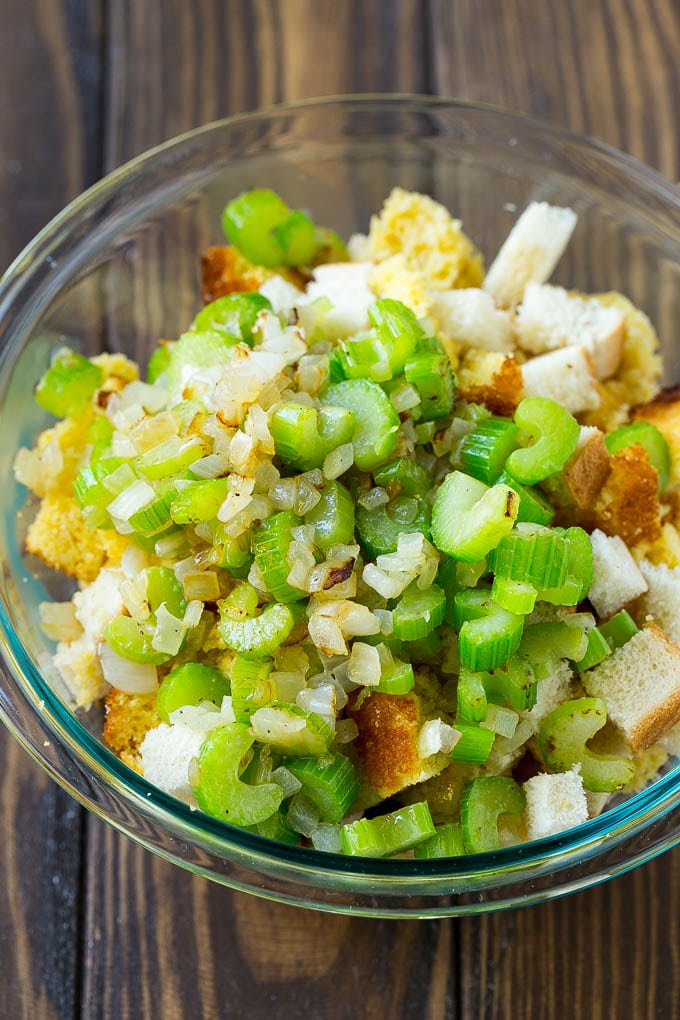 Bread cubes, cornbread and sauteed celery and onions in a bowl.