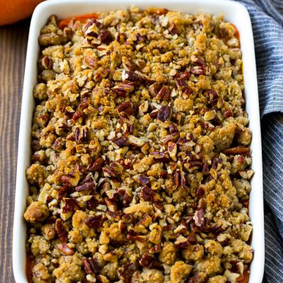 Sweet potato casserole with pecans and brown sugar streusel in a baking dish.