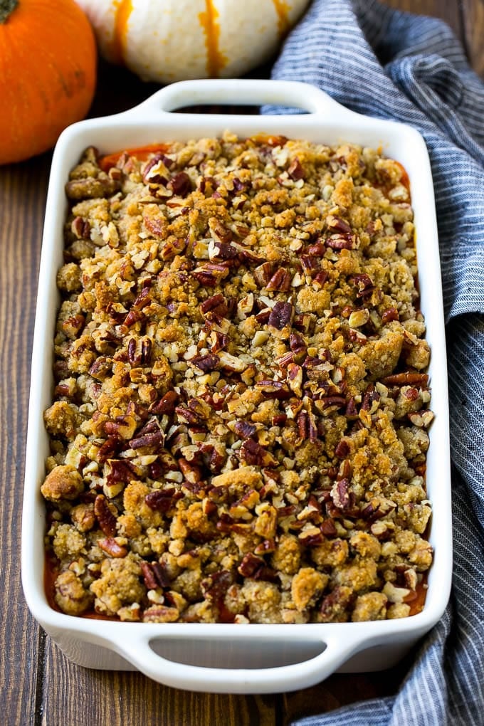 Sweet potato casserole with pecans and brown sugar streusel in a baking dish.