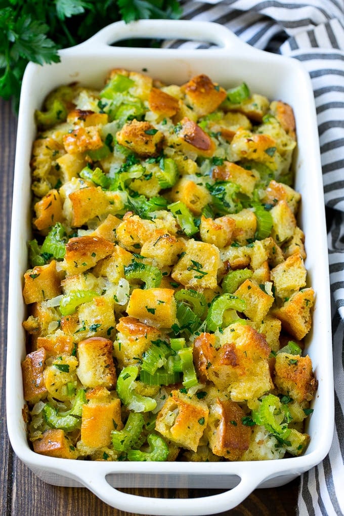 Baked turkey stuffing in a dish topped with fresh parsley.