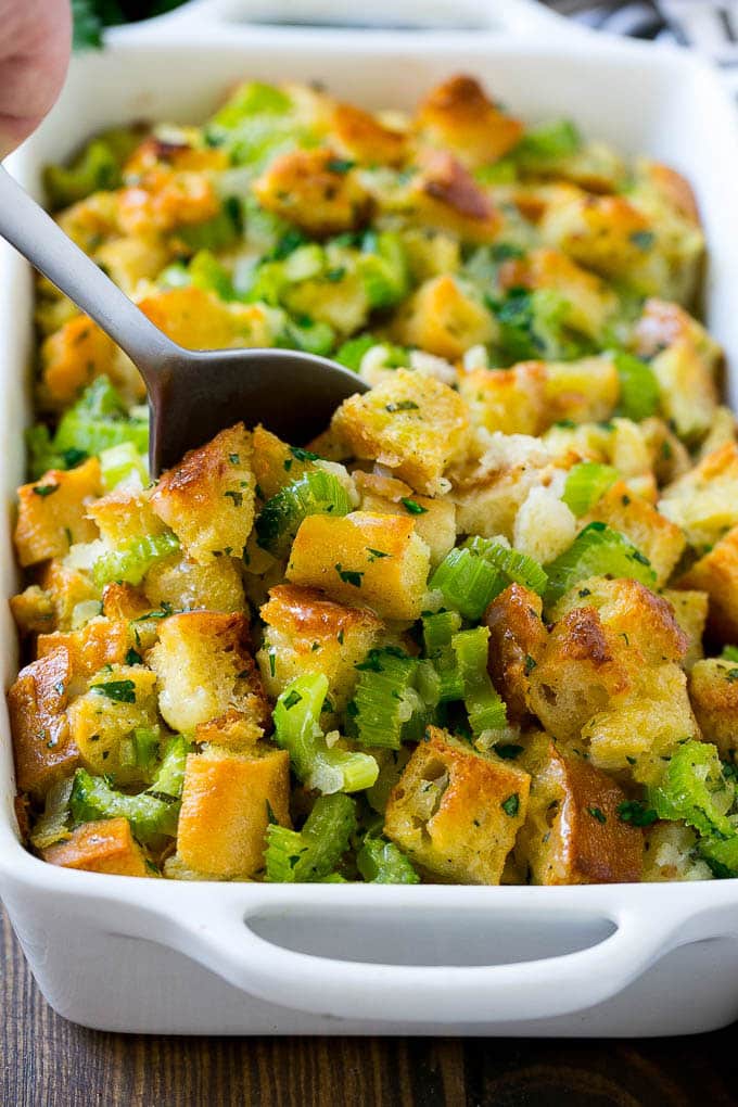 Turkey stuffing in a casserole dish with a serving spoon in it.