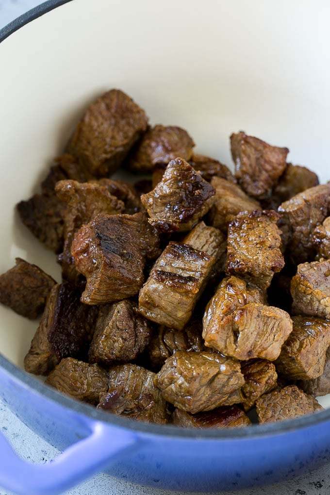 Browned pieces of beef stew meat in a soup pot.