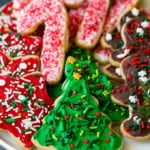 A serving plate of Christmas sugar cookies decorated with frosting and sprinkles.