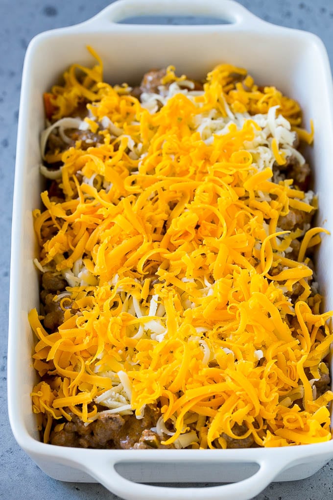 A casserole dish layered with Dorito chips, ground beef and shredded cheese.
