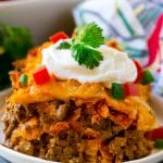 A piece of Dorito casserole with layers of tortilla chips, beef and cheese.