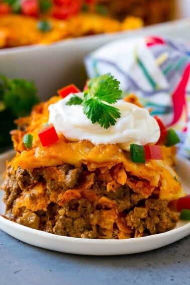 A piece of Dorito casserole with layers of tortilla chips, beef and cheese.