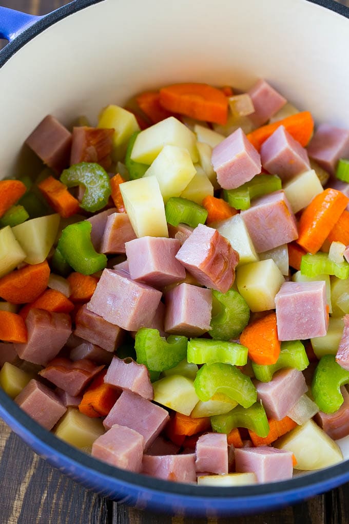 Diced ham, carrots, potatoes and celery in a soup pot.