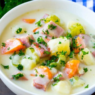 A bowl of ham and potato soup loaded with veggies in a creamy broth.