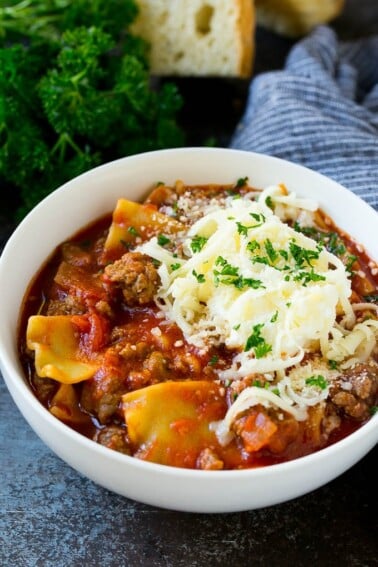 A bowl of lasagna soup topped with ricotta, parmesan and mozzarella cheeses.