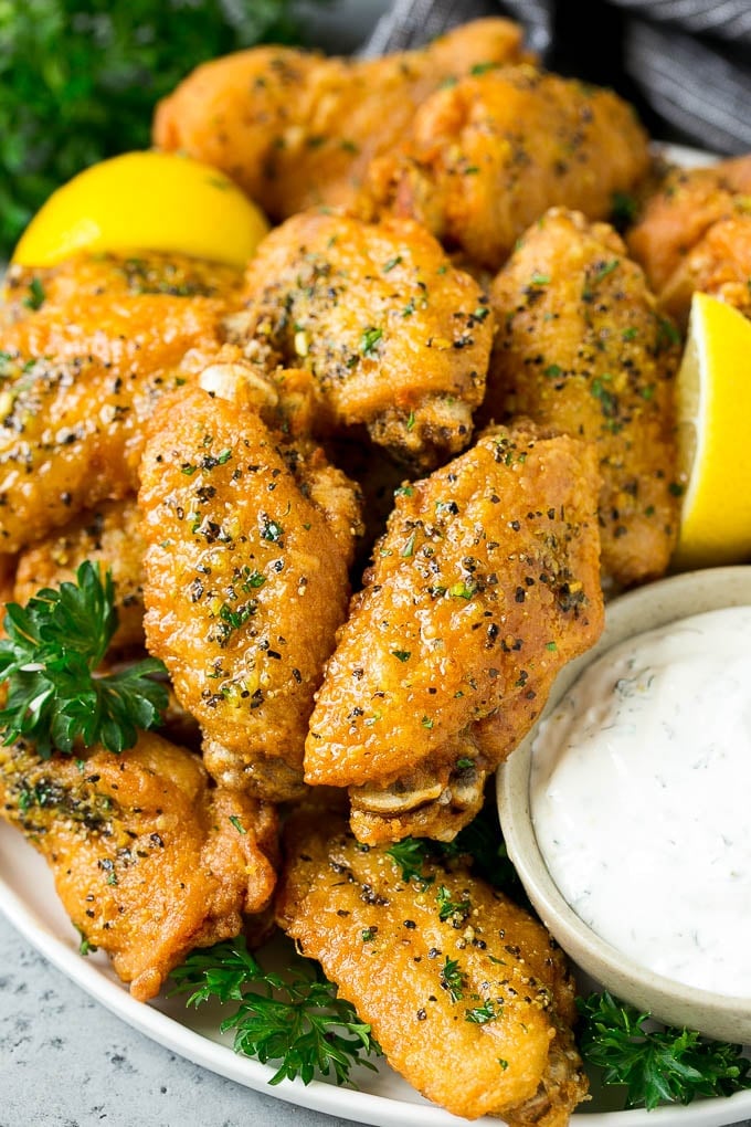 Lemon pepper wings topped with parsley and served with a side of ranch for dipping.