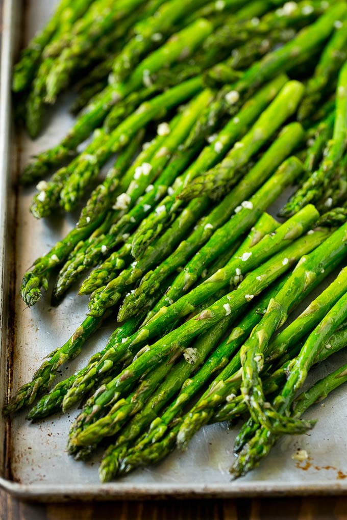 Roasted stalks with garlic and olive oil on a baking sheet.