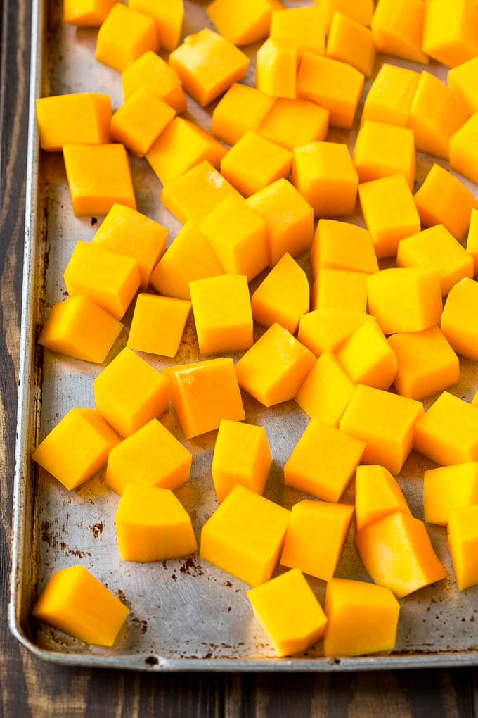 Raw cubed squash on a sheet pan.