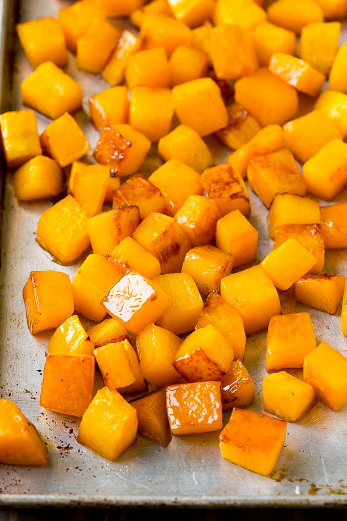 Caramelized cooked butternut squash on a sheet pan.