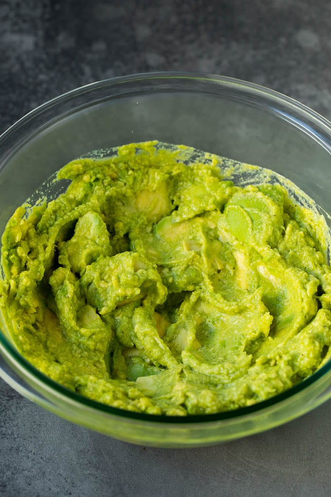 Mashed avocado in a mixing bowl.