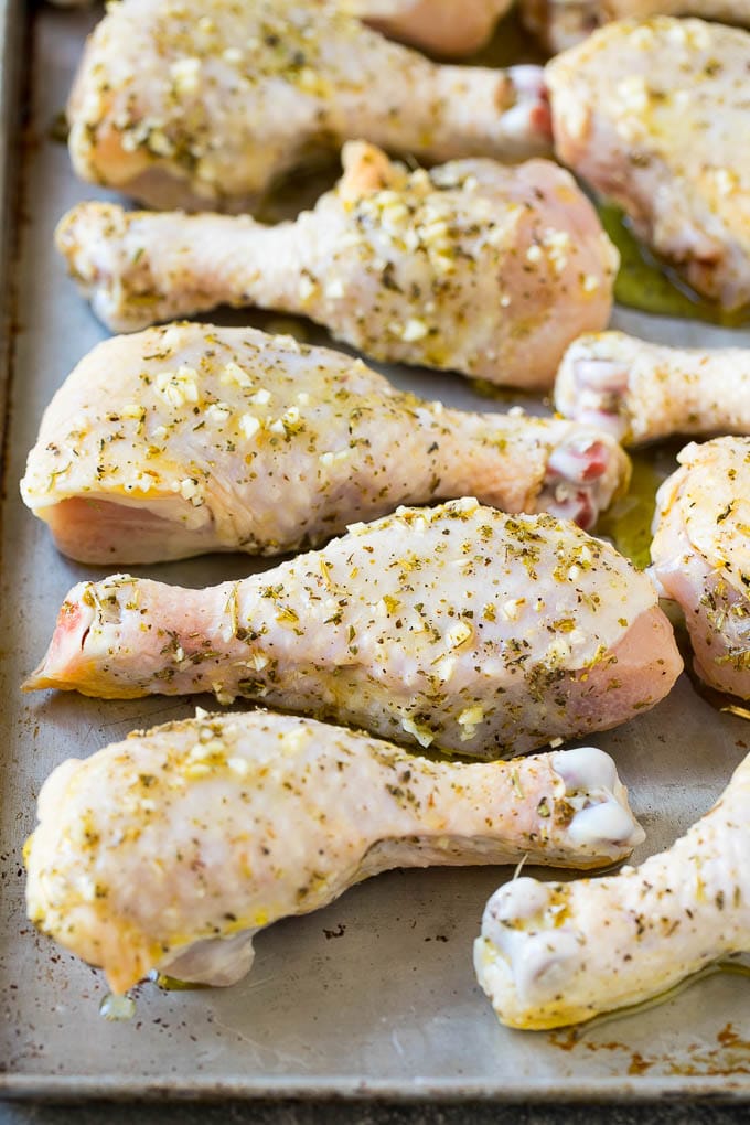 Marinated chicken drumsticks on a sheet pan, ready to go into the oven.