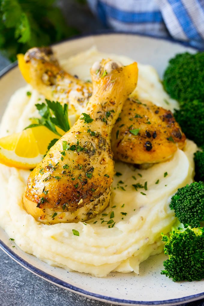 Baked chicken drumsticks served with mashed potatoes and broccoli.
