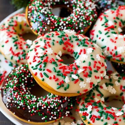 A serving plate of baked donuts frosted in dark and white chocolate and topped with sprinkles.