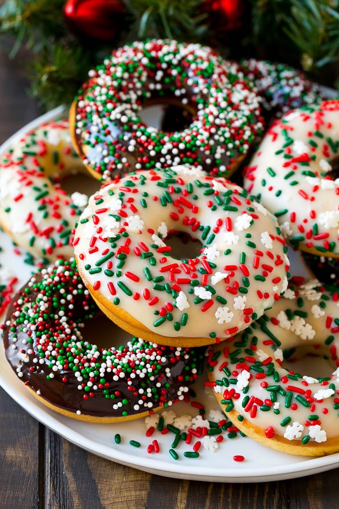 A serving plate of baked donuts frosted in dark and white chocolate and topped with sprinkles.