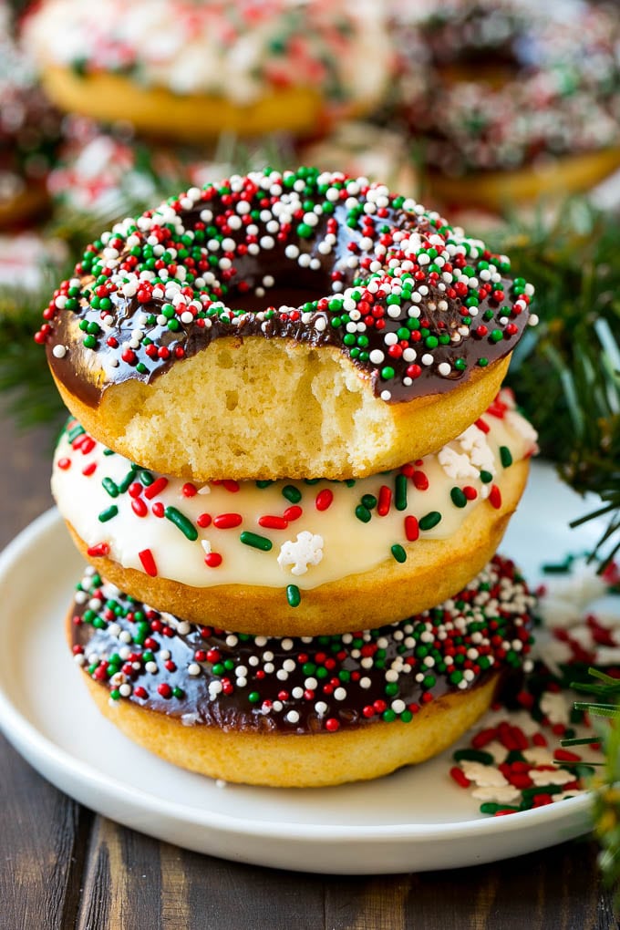 A stack of donuts with a bite out of one.