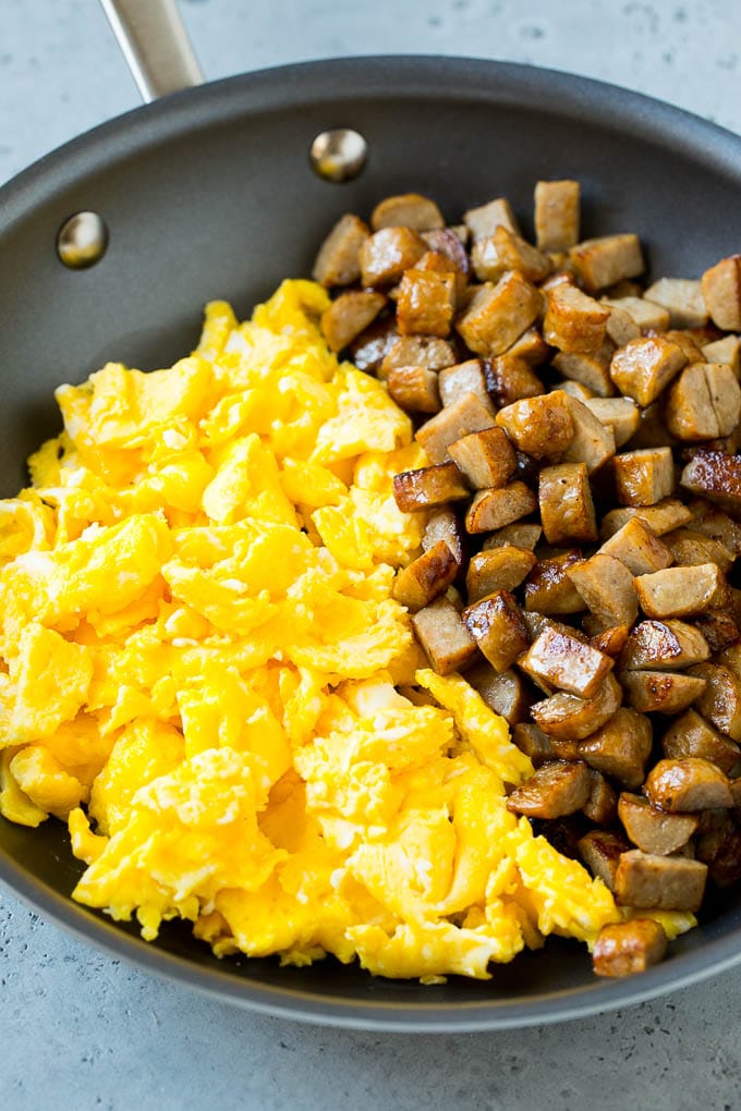 Diced sausage and scrambled eggs in a pan.