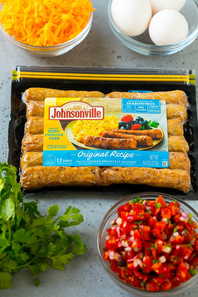 A package of sausage links along with bowls of pico de gallo, eggs and shredded cheese.