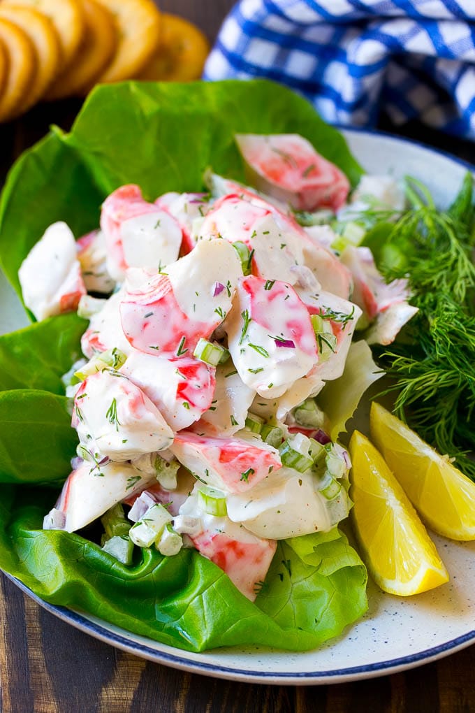 Crab salad served on a bed of lettuce with a side of crackers.