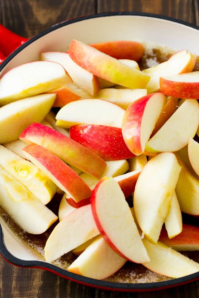Sliced apples in a pan with butter, sugar and cinnamon.